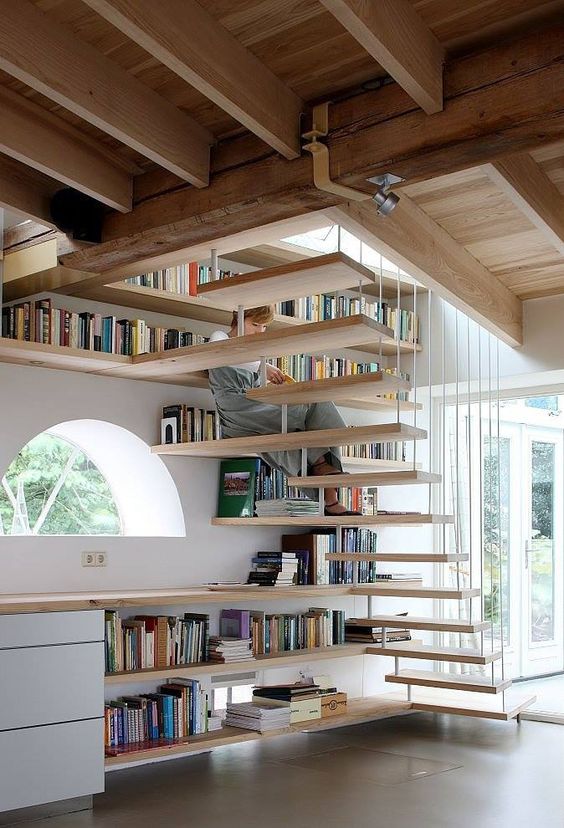 Решение лестницы-невидимки, объединенной с рабочим столом и с библиотекой, выглядит легко и современно
